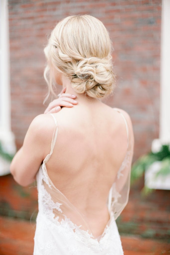 A bride with her back to the camera wearing an open back wedding dress. Must-have wedding photos by Marcela Plosker, a Boston wedding photographer.