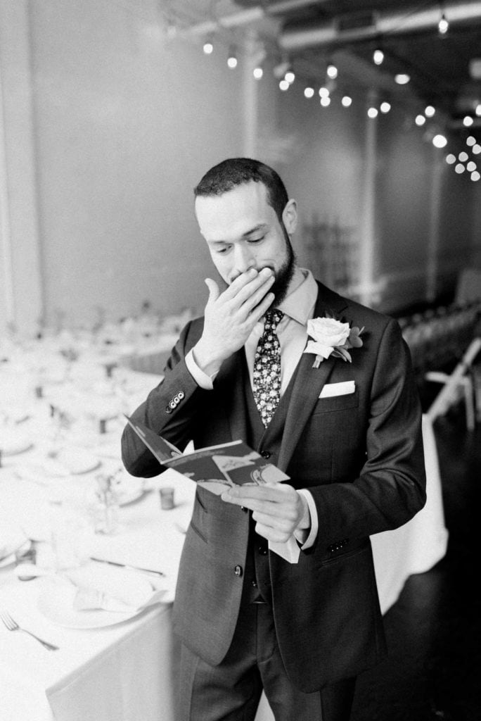 A groom reading a letter from his fiance on her wedding day. Must-have wedding photos by Marcela Plosker, a Boston wedding photographer.