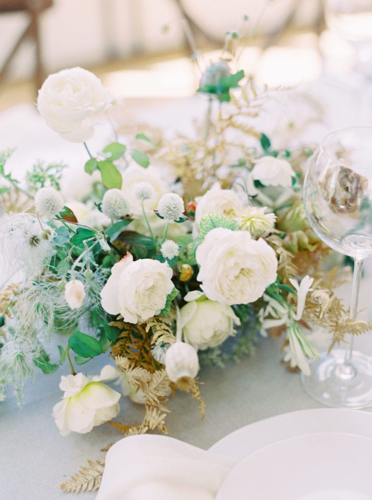 Close up shot of a white and green wildflower table centerpiece. Must-have wedding photos by Marcela Plosker, a Boston wedding photographer.