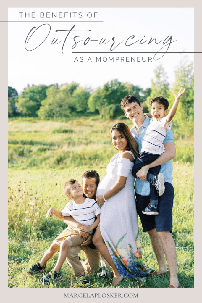 A pregnant mom smiles with her husband and three sons as they pose for a family photo in a field. Image overlaid with text that reads The Benefits of Outsourcing as a Mompreneur.