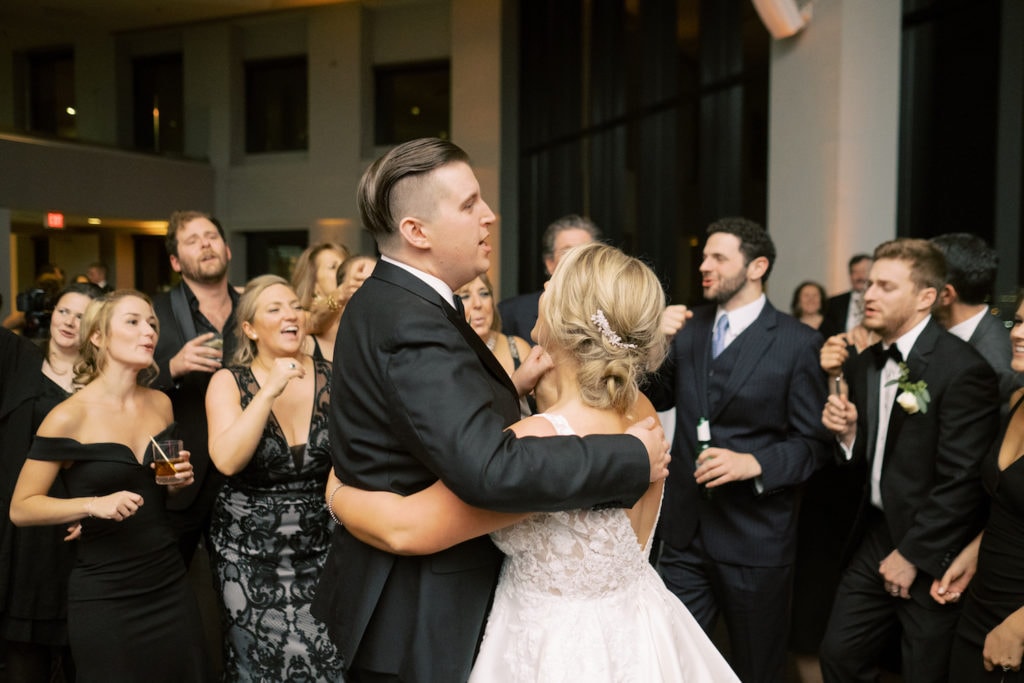 Image of bride and groom dancing while their wedding guests dance around them.