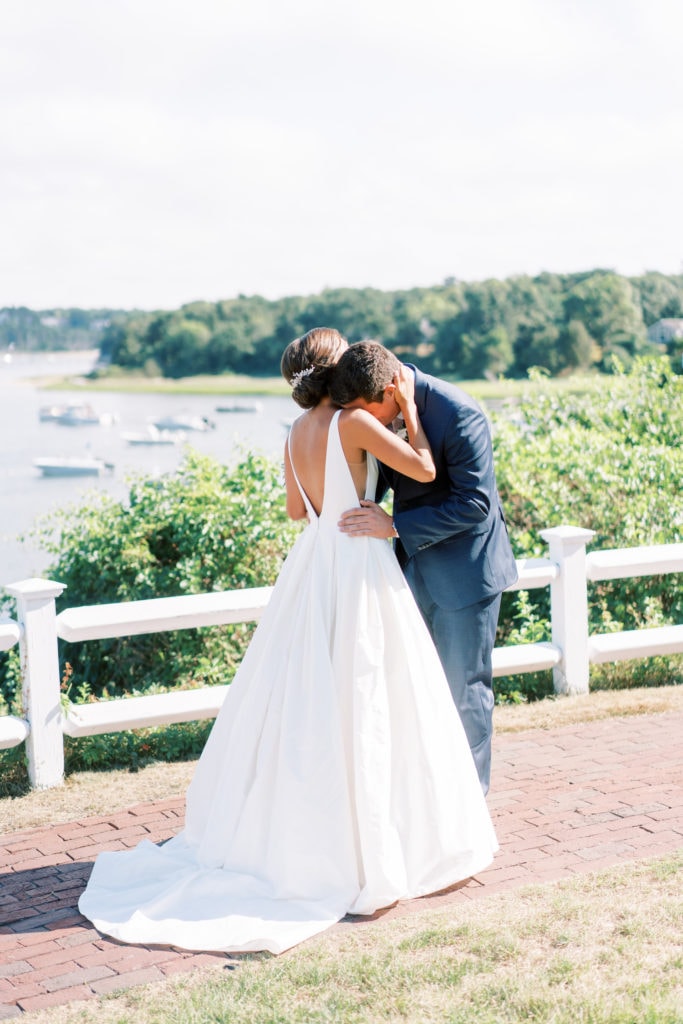 Image of groom embracing bride during the first look of their wedding by Boston wedding photographer Marcela Plosker.