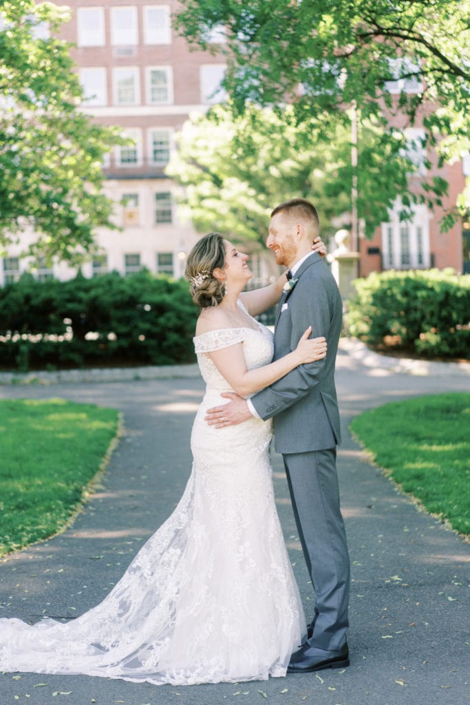 Bride and groom look at each other endearingly as they share a hug at a park during their wedding shoot