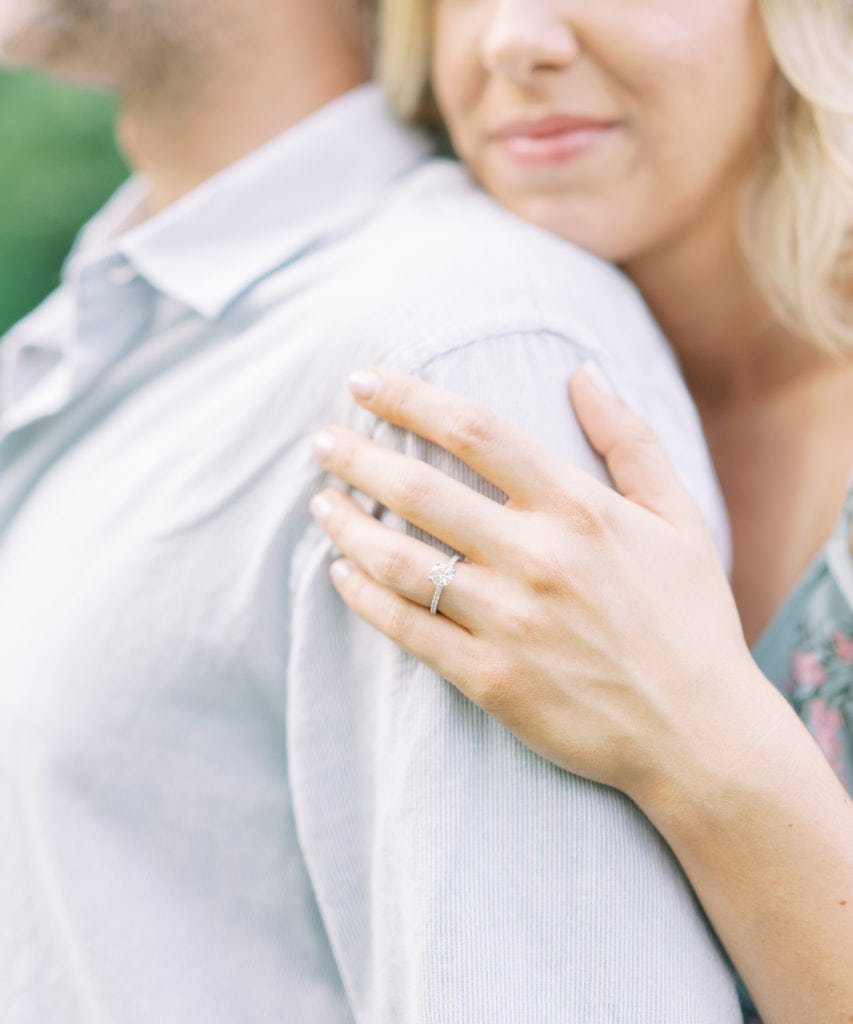 Engaged couple posing for engagement shoot with an engagement ring. Photographed by North Shore, Massachusetts wedding photographer Marcela Plosker.