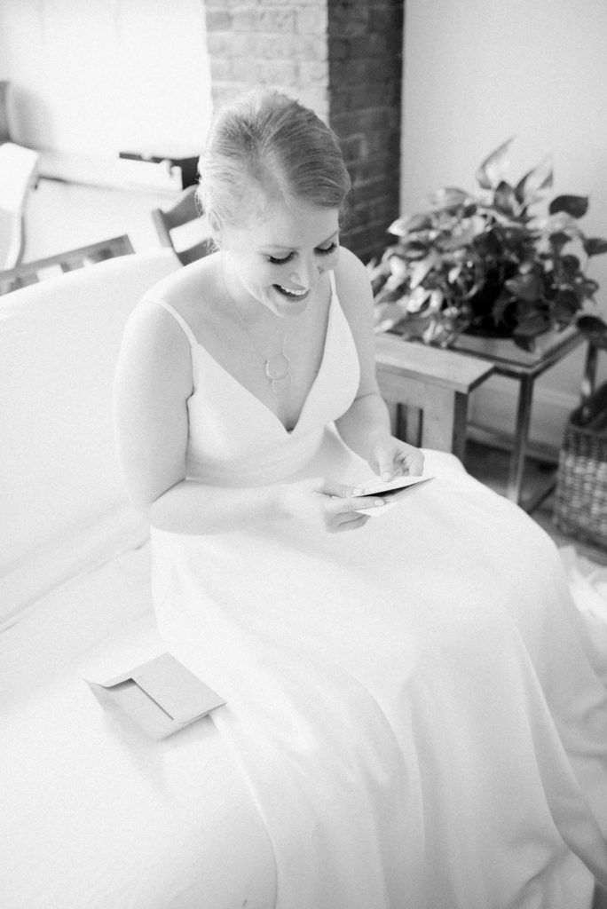 A bride reading a letter from her fiance on her wedding day. Must-have wedding photos by Marcela Plosker, a Boston wedding photographer.