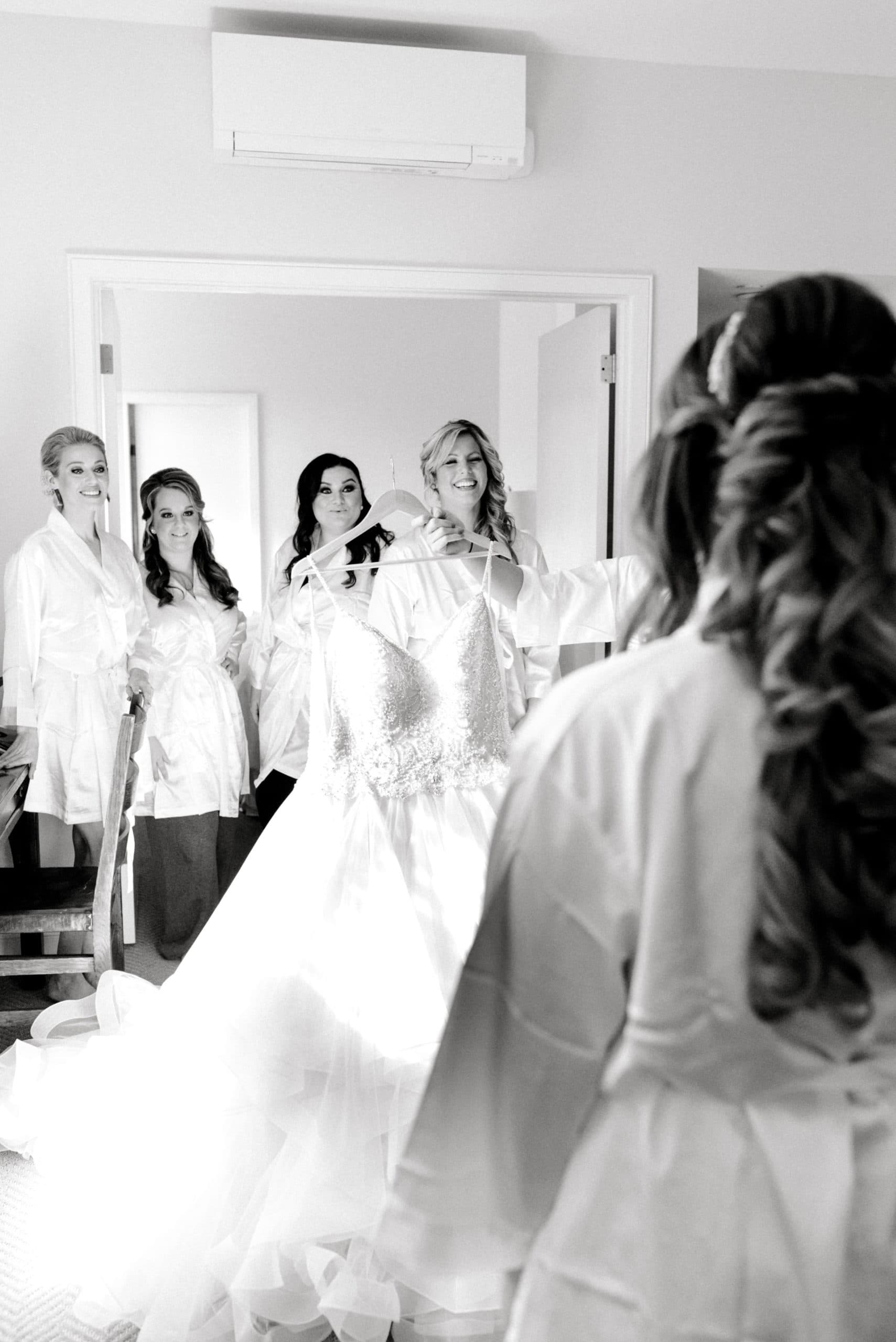 A bride gets ready for her wedding with her bridesmaids. Must-have wedding photos by Marcela Plosker, a Boston wedding photographer.