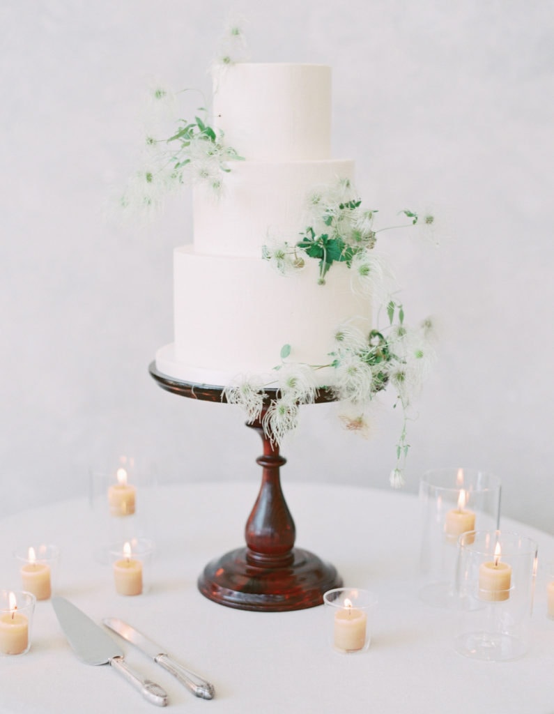 A wedding cake decorated with sprigs of wildflowers. Must-have wedding photos by Marcela Plosker, a Boston wedding photographer.