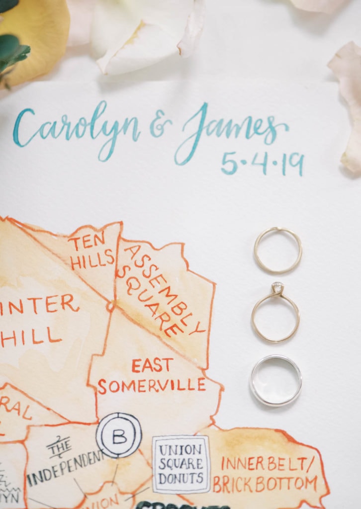 A couple's wedding rings laying on a map. Must-have wedding photos by Marcela Plosker, a Boston wedding photographer.