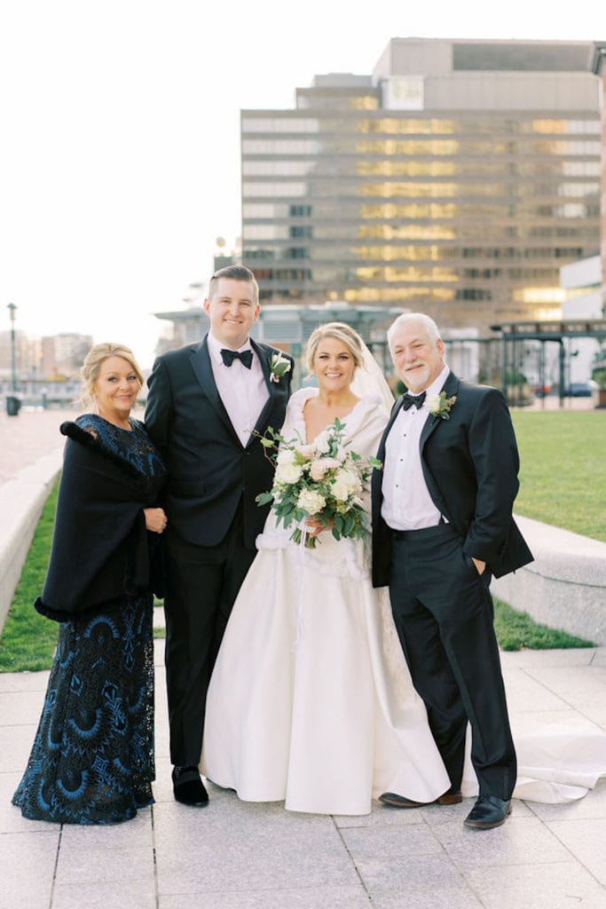 Bride and groom pose with the groom's parents as an example of family wedding photos and how to do them right. Photograph by Boston, Massachusetts wedding photographer Marcela Plosker.