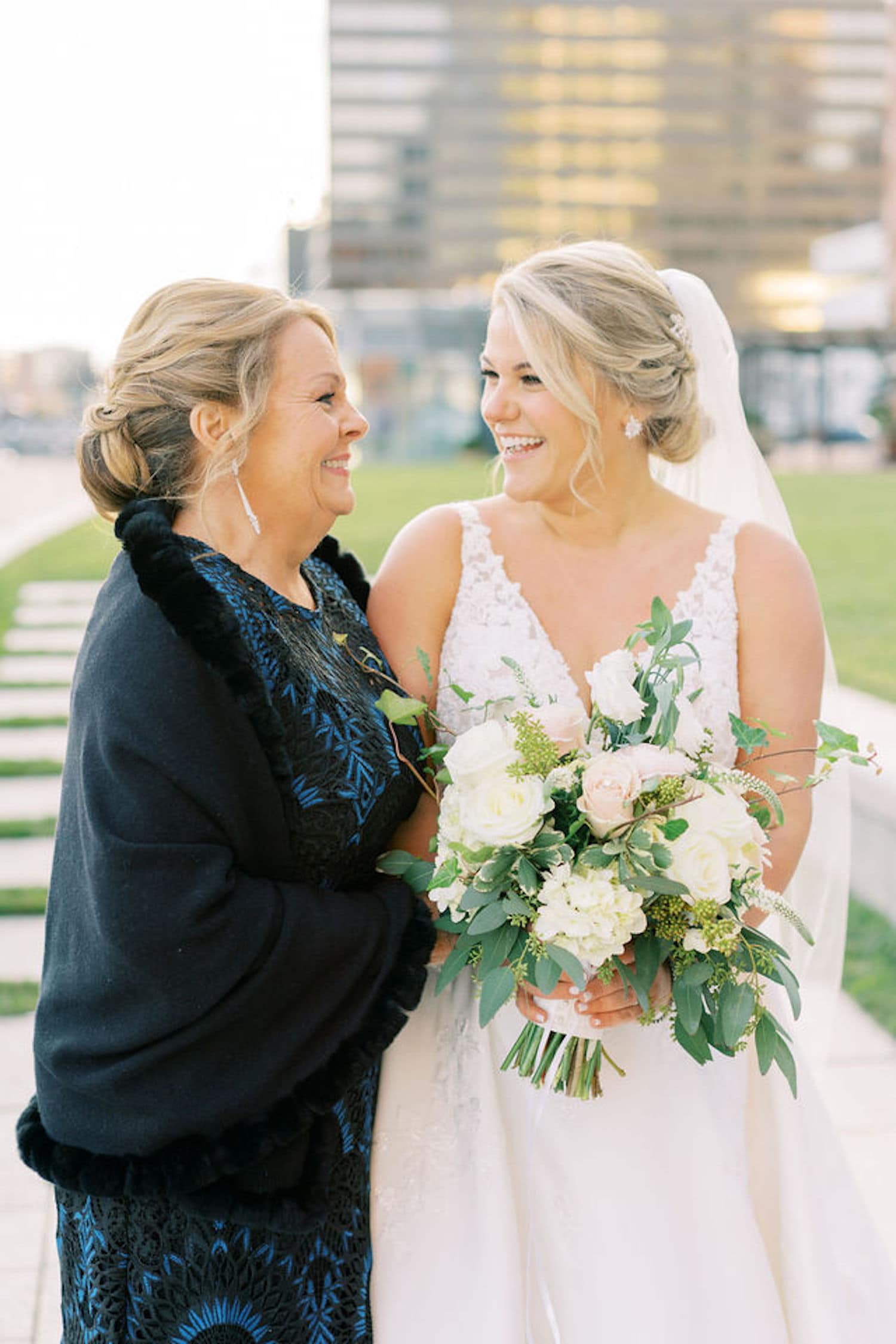 A bride and her mom smile during a family wedding photo as an example of Family Wedding Photos: How to do them Right. Photograph by Marcela Plosker, Boston Massachusetts wedding photographer.