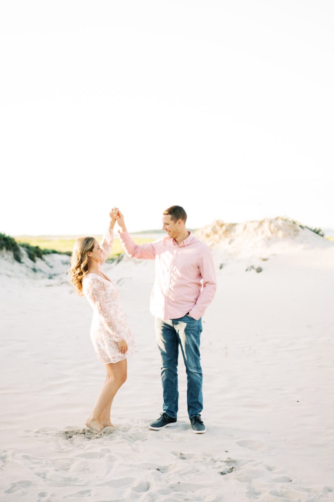A bride to be and a groom to be dance on the beach in North Shore Massachusetts. By Boston wedding photographer Marcela Plosker.