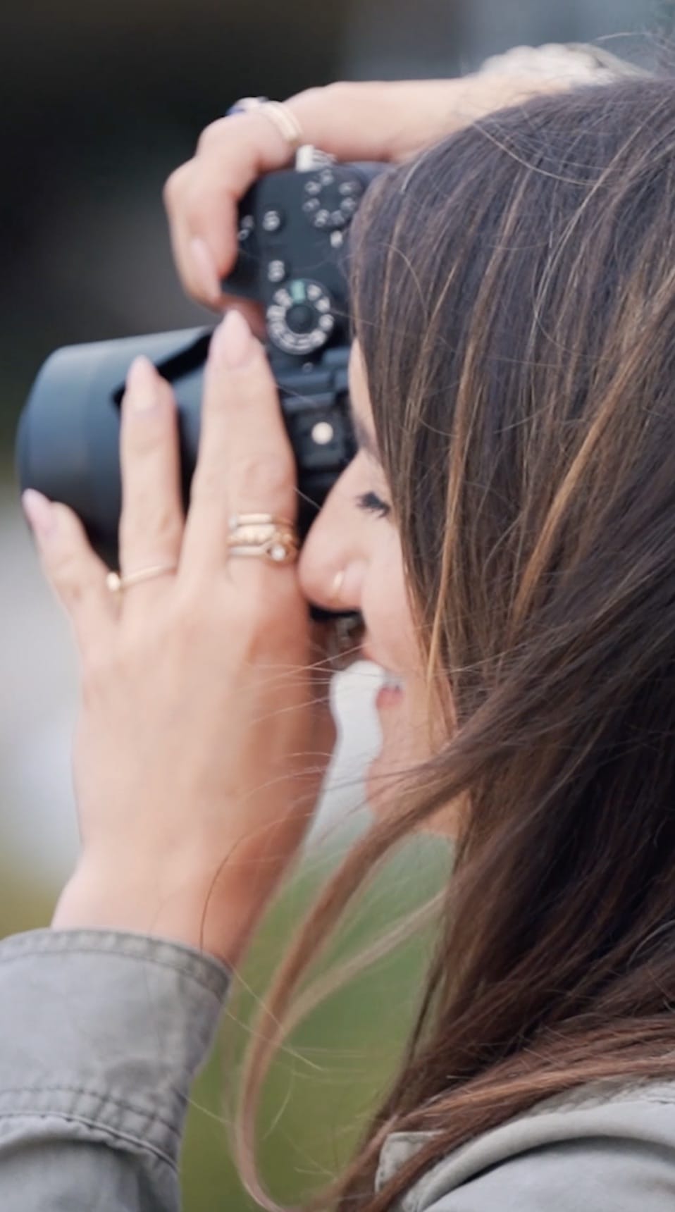 A close up image of Marcela Plosker, a Boston wedding photographer, taking a photo during a wedding.