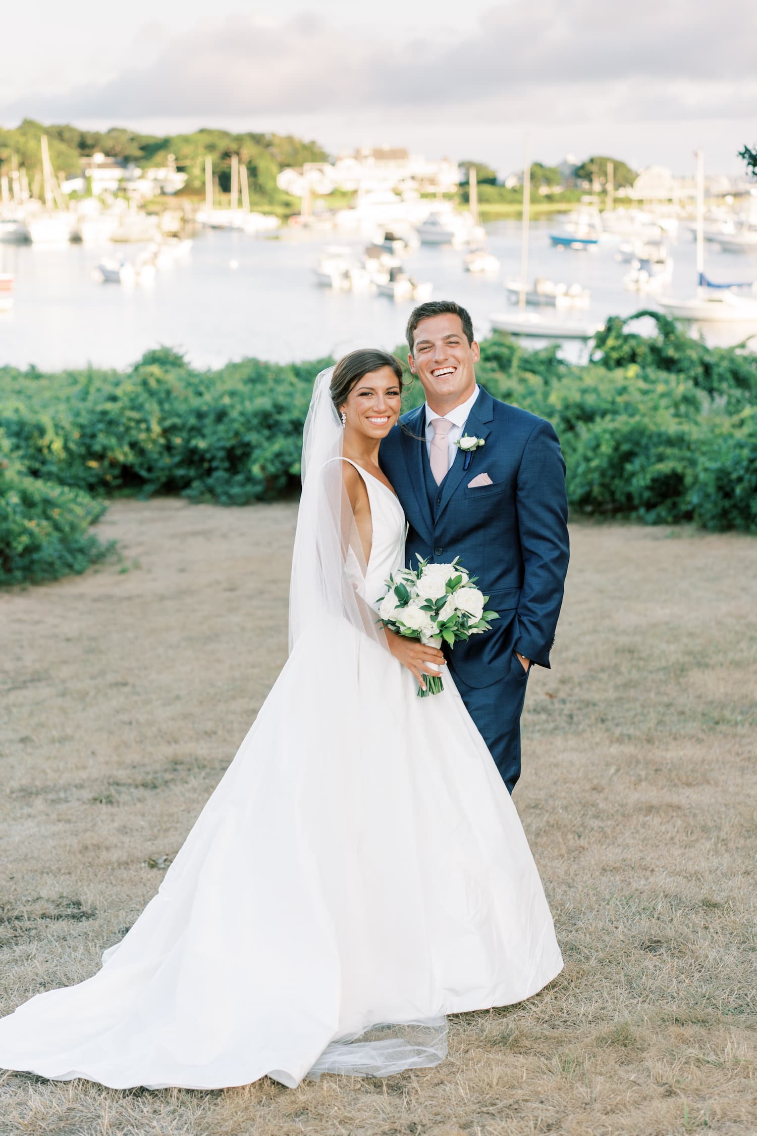 Bride and groom stand on the beach at their Cape Cod wedding venue, photographed by Marcela Plosker, a Boston wedding photographer.