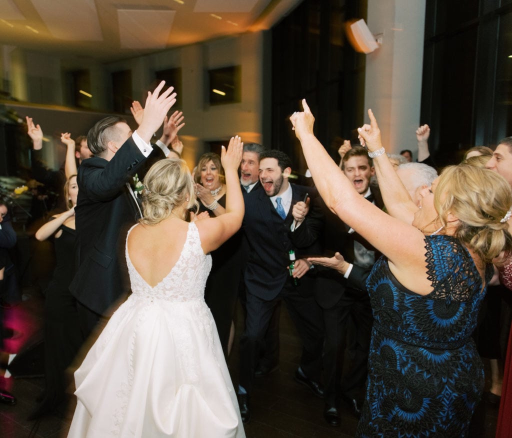 Image of bride and groom dancing with their wedding guests, an example of a shot from a wedding photography shot list.