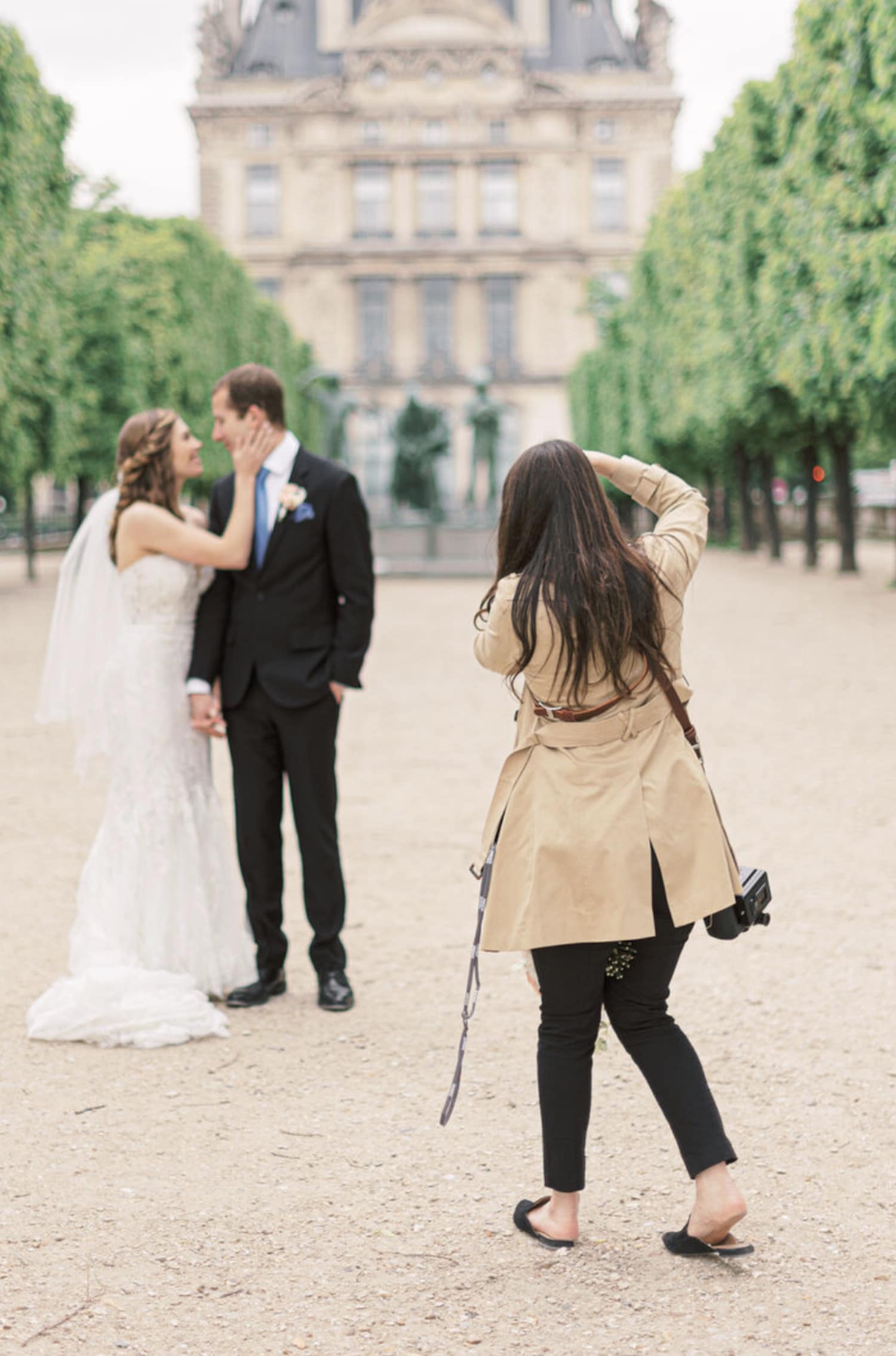 How Much Do Wedding Photographers Make (2021). Marcela Diaz takes photo of bride and groom outside a Victorian mansion