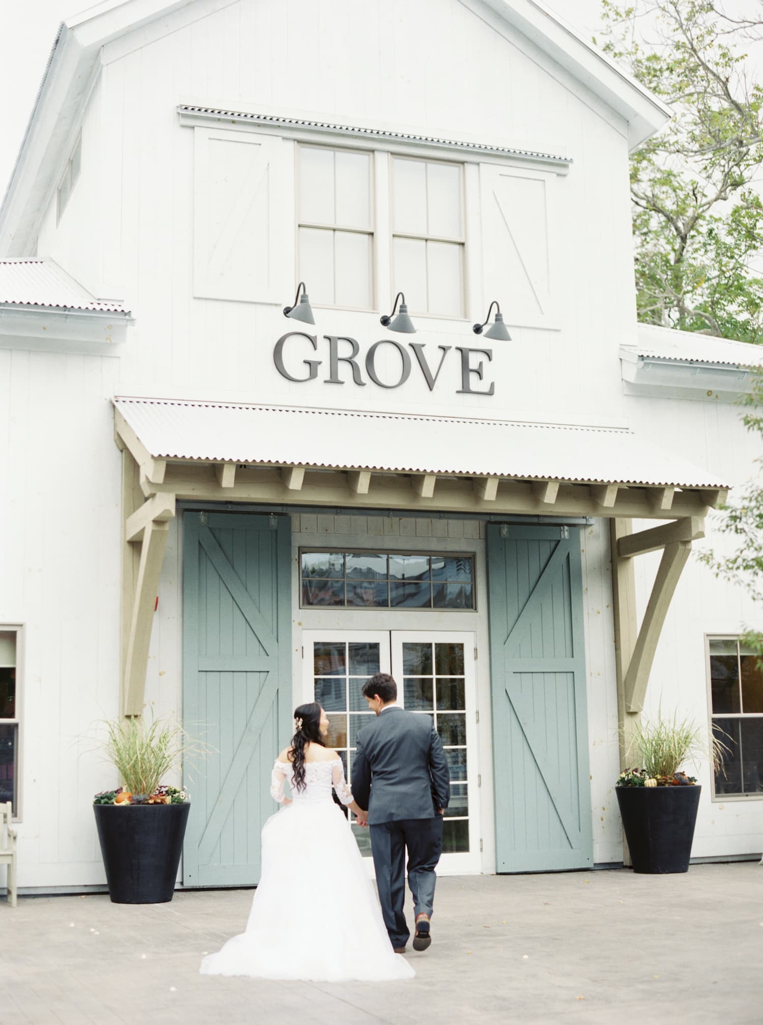 8 Secret Wedding Planning Tips I Wish I Would Have Known. Bride and groom stroll into The Grove during their wedding shoot.