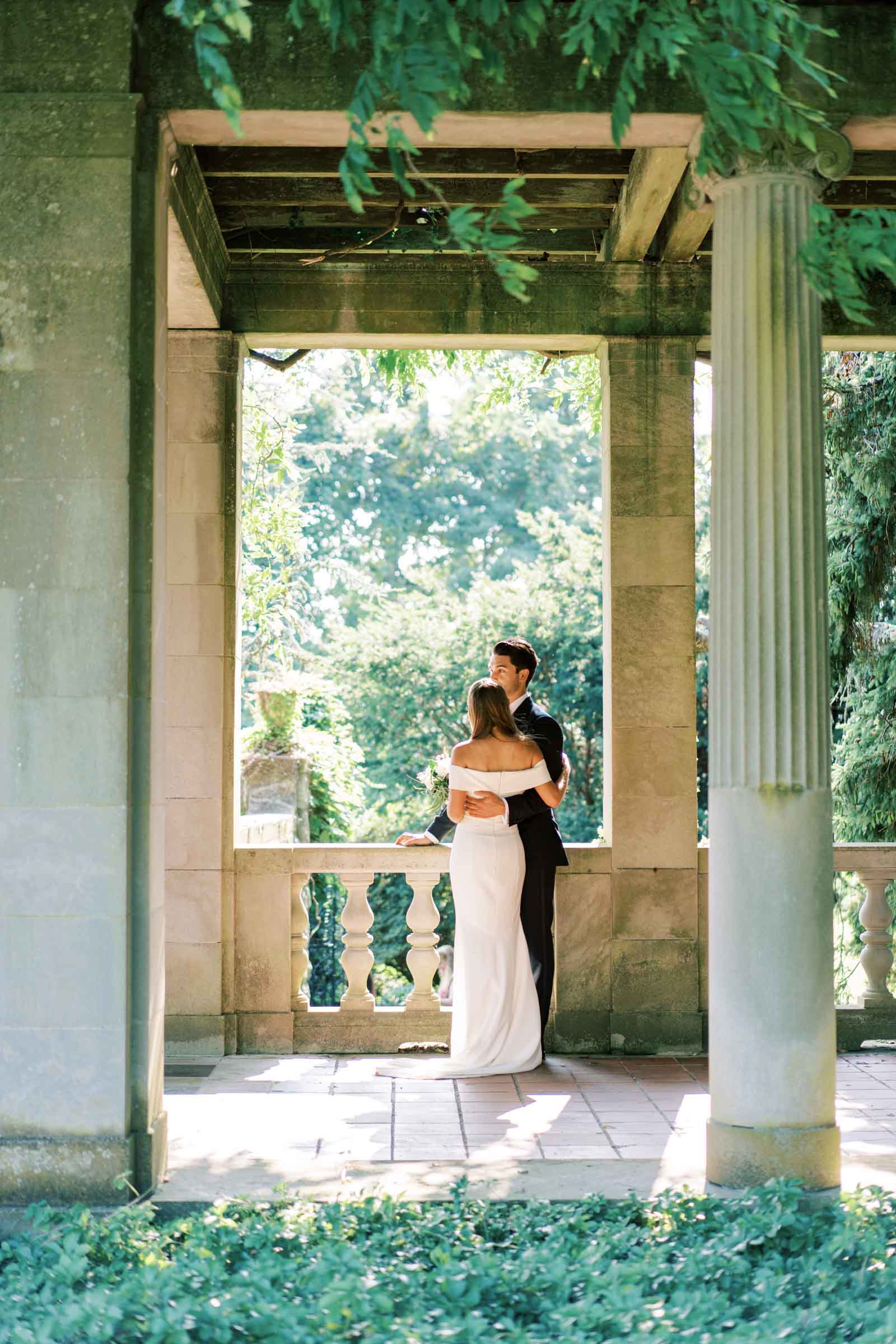 Bride and groom embrace under an archway during their wedding at a breathtaking historical venue in Massachusetts