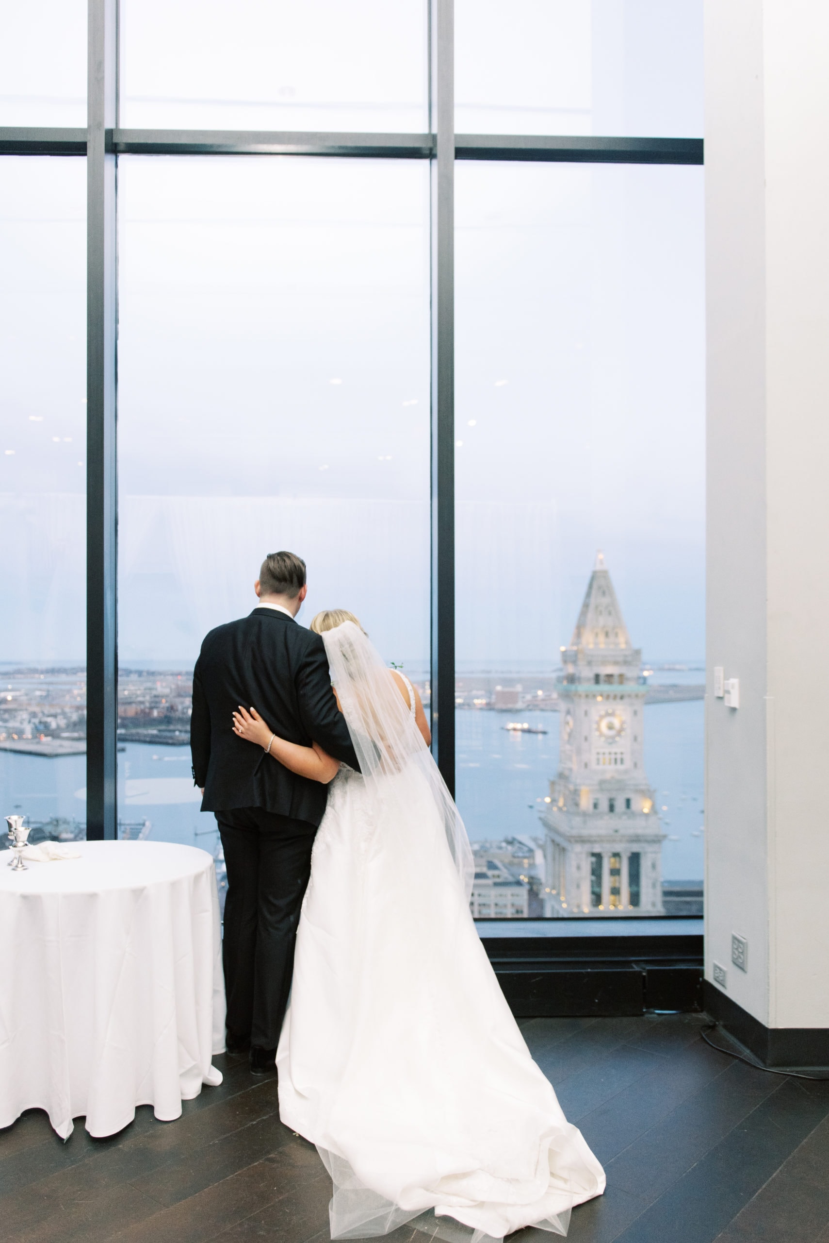 Bride and groom standing next to each other with their backs to the camera looking at the view from the State room