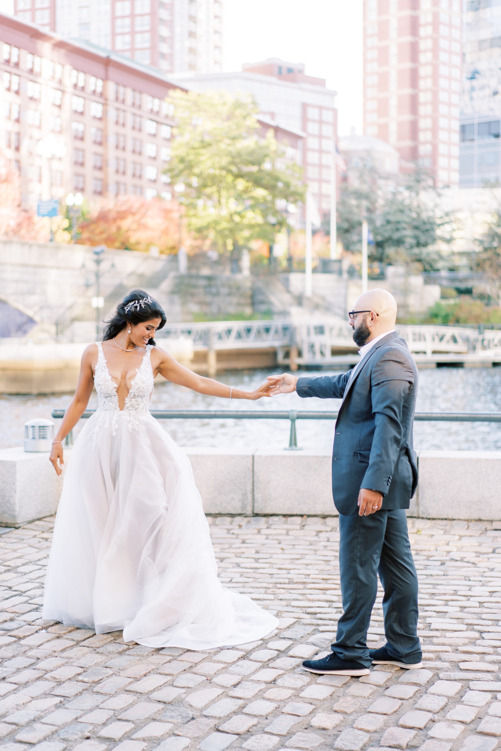 Bride and groom posing with each other as they hold hands near Boston Harbor Hotel, one of the luxury hotel wedding venues in Boston