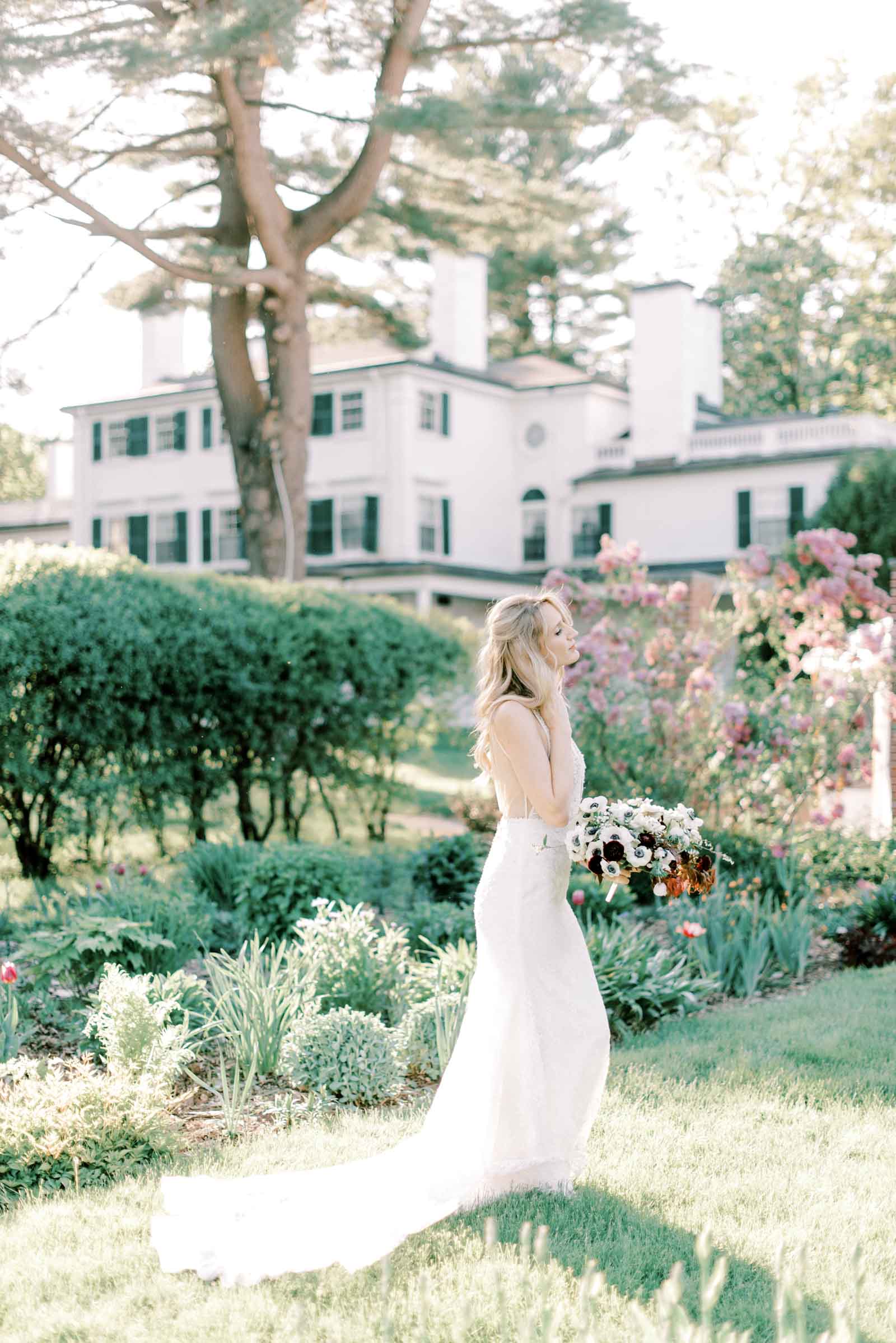 Stunning bride closing her eyes and showing her side profile at the garden of her New England wedding venue, photographed by Marcela Diaz