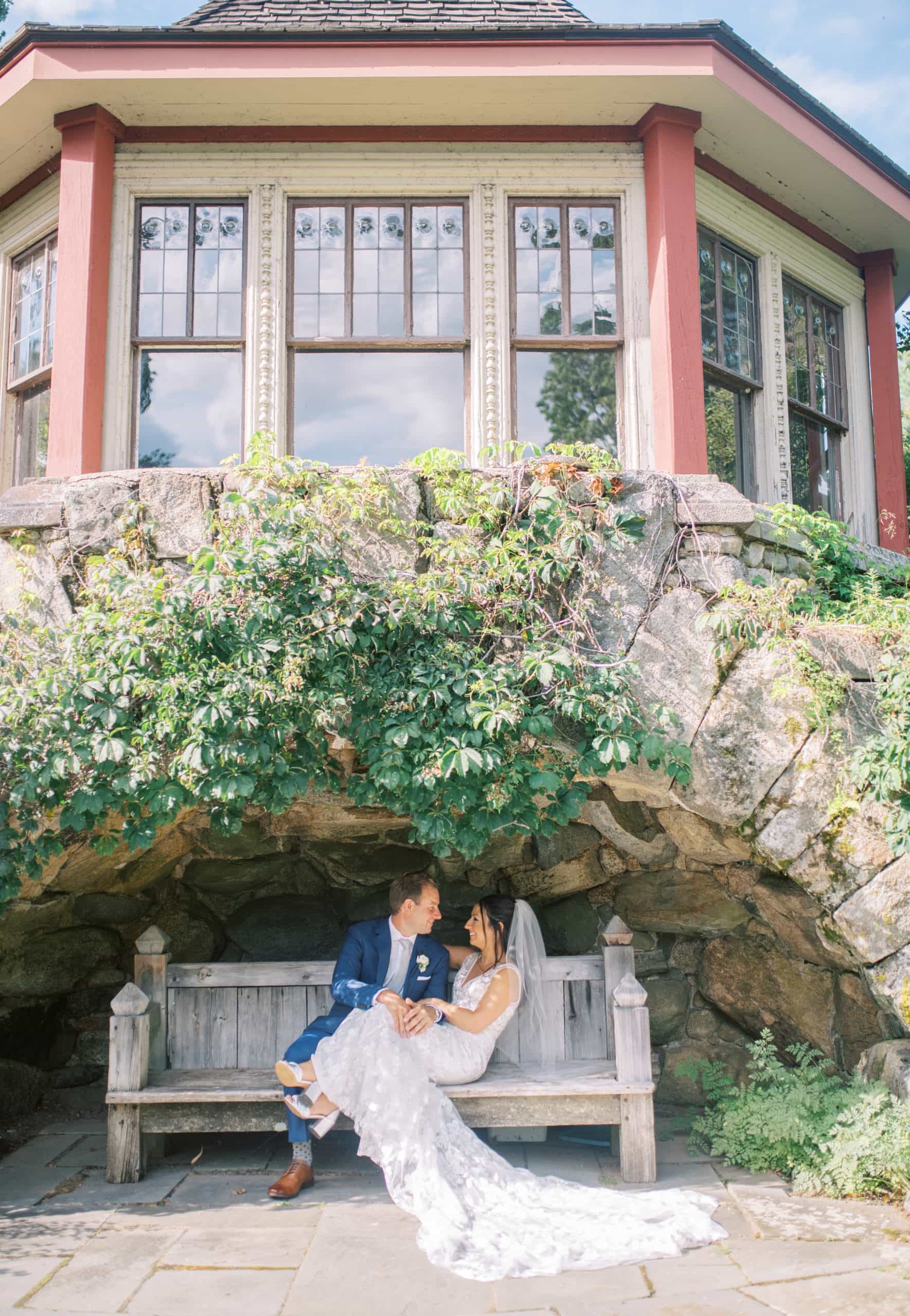 Bride and groom sitting on a wooden bench under a cave below the venue at The Dane Estate, taken by Marcela Diaz Photography