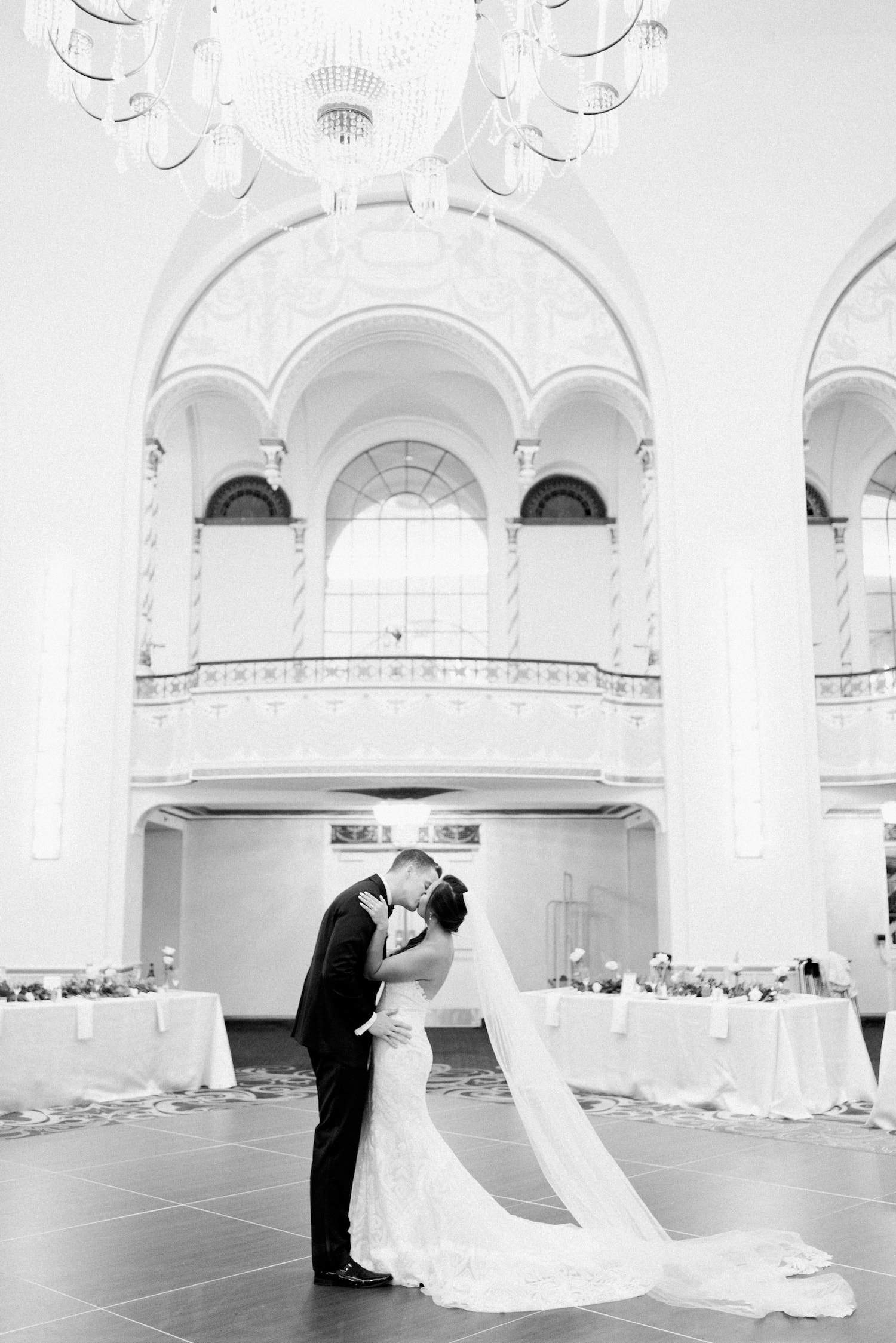 Black and white photo of bride and groom sharing a kiss at the grand ballroom, captured by Marcela Diaz Photography