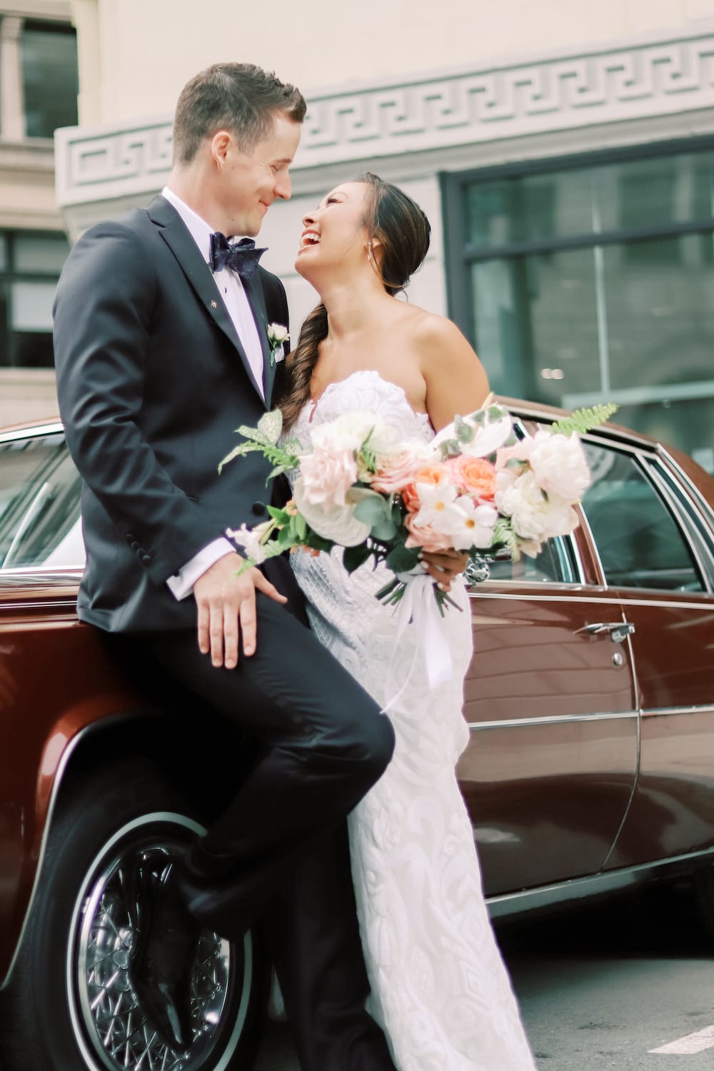 Fairmont Copley Plaza Wedding in Boston. Couple smiling and posing in front of a red vintage car.