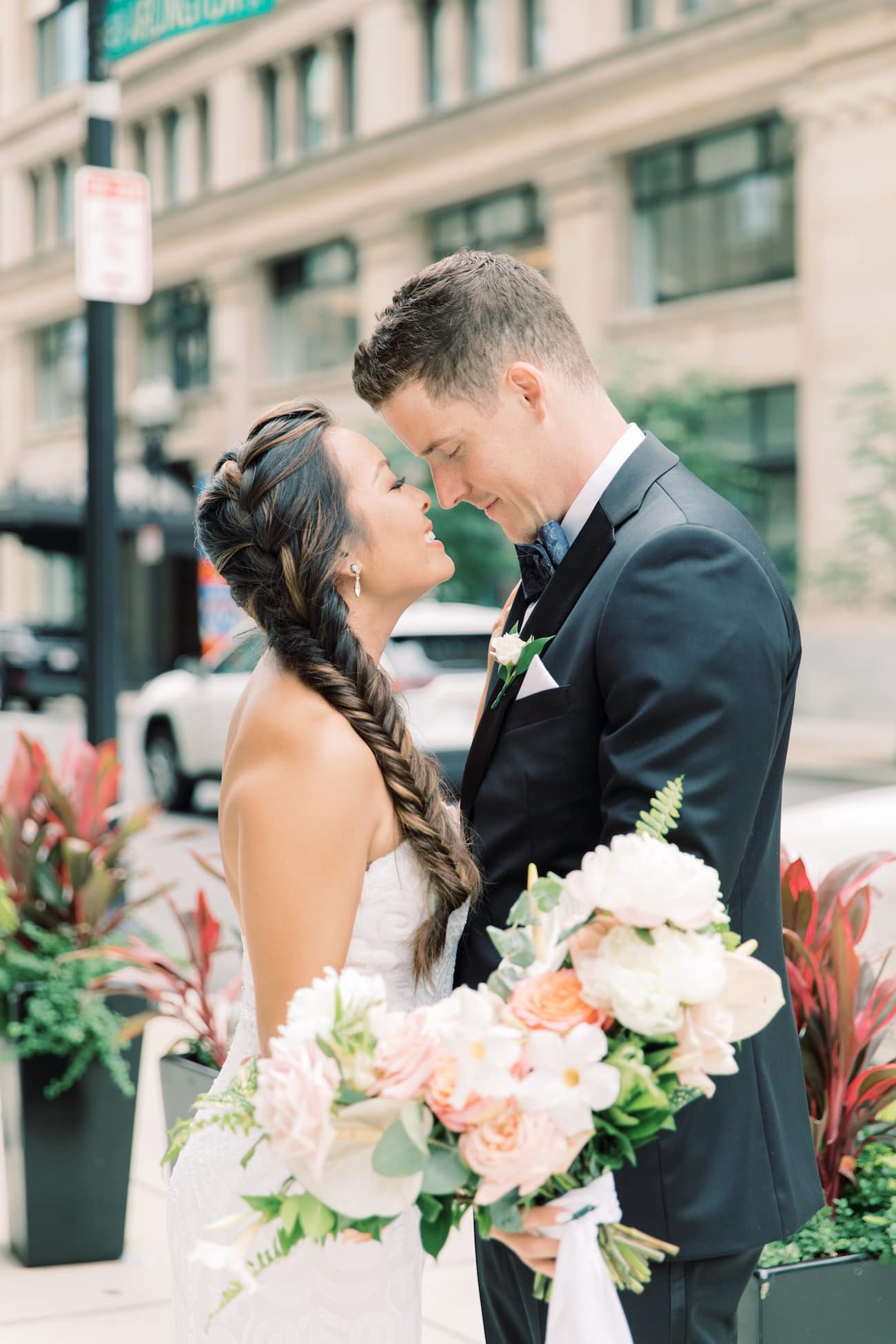 Bride and groom standing in front of each other and leaning in for a kiss during their Fairmont Copley Plaza wedding shoot with Marcela Diaz