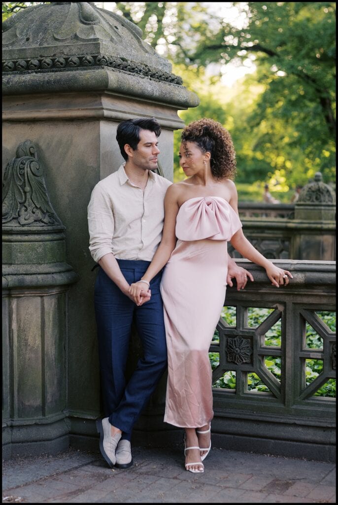 Engaged couple editorial pose in Central Park with pink bow dress.